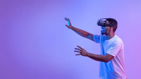 Virtual reality development showcased by a man wearing VR glasses, interacting with a digital simulation.